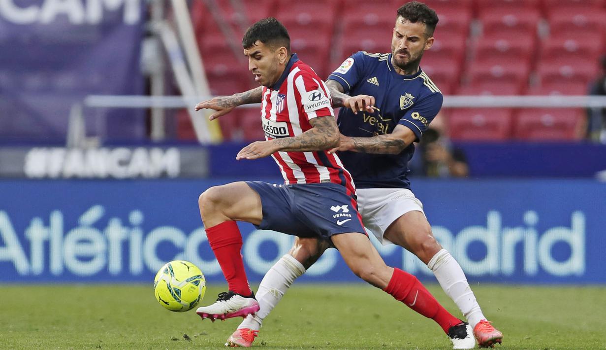 Pemain Atletico Madrid, Angel Correa, berusaha melewati pemain Osasuna, Ruben Garcia, pada laga Liga Spanyol di Stadion Wanda Metropolitano, Minggu (16/5/2021). Atletico Madrid menang dengan skor 2-1. (AP/Manu Fernandez)