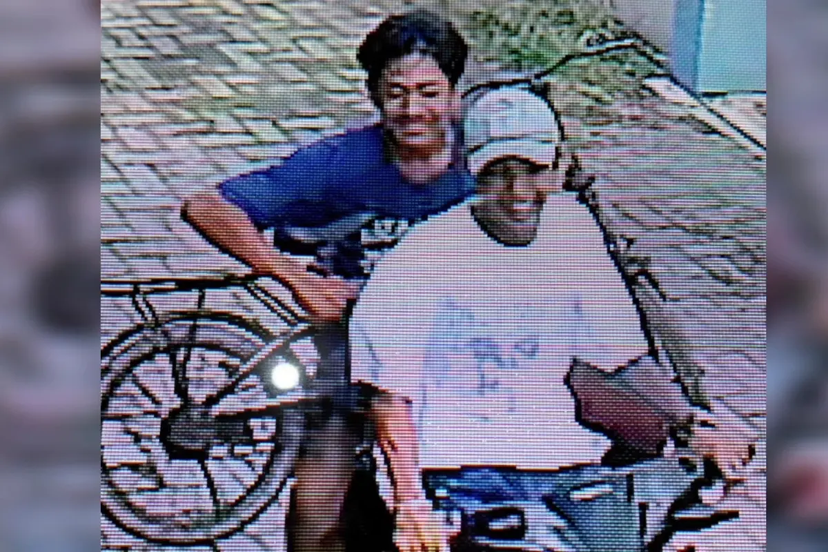 Tangkapan layar rekaman kamera CCTV saat dua maling sepeda senyum semringah.