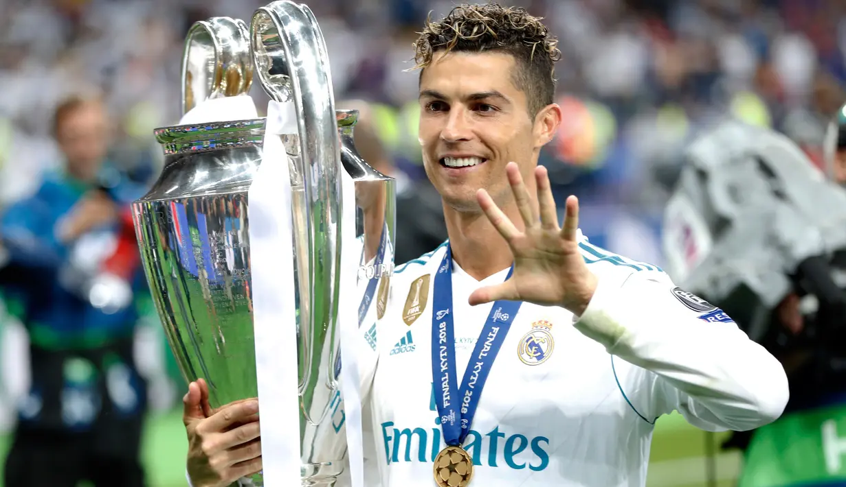 Penyerang Real Madrid Cristiano Ronaldo menggendong trofi sambil menunjukkan lima jarinya usai menjadi juara Liga Champions di Stadion NSK Olimpiyskiy, Ukraina (26/5). (AP/Pavel Golovkin)