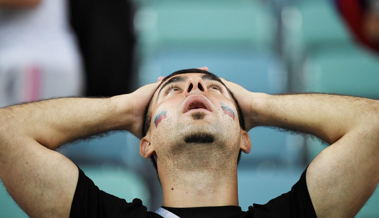 Seorang suporter tampak kecewa usai Rusia kalah dari Kroasia pada laga perempat final Piala Dunia di Stadion Olimpiade Fisht, Sabtu (7/7/2018). Rusia kalah adu penalti dengan skor 3-4 dari Kroasia. (AFP/Kirill Kudryavtsev)