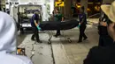 Fans Rapper Takeoff Migos menonton dan merekam saat pemeriksa medis mengeluarkan jenazah dari lokasi penembakan di 1201 San Jacinto, di Houston, Texas, Selasa (1/11/2022). Tiba-tiba terjadi pertengkaran. Dan saat itulah orang tak dikenal melepas tembakan dan mengenai Takeoff.  (Annie Mulligan/Houston Chronicle via AP)