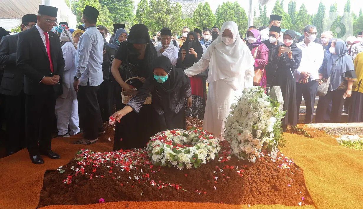 Istri Almarhum Azyumardi Azra menaburkan bunga di atas pusara sang suami di Taman Makam Pahlawan Kalibata, Jakarta, Selasa (20/9/2022). Prosesi pemakaman ditutup dengan pembacan doa yang dipimpin Imam Besar Masjid Istiqlal Nasaruddin Umar. (Liputan6.com/Herman Zakharia)