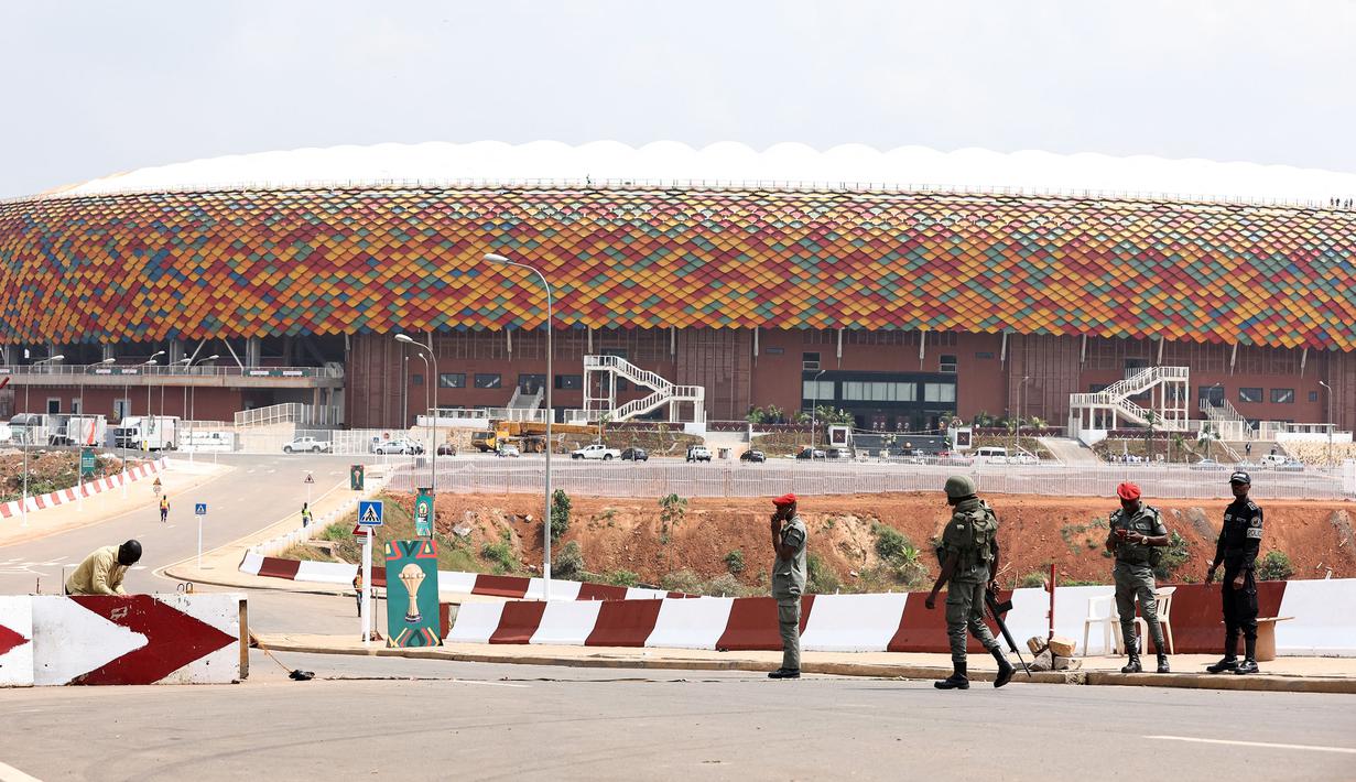 Sejumlah tentara Kamerun berpatroli di pintu masuk Stadion Olembe yang terletak di Yaounde, pada 7 Januari 2022. Stadion yang berkapasitas 60.000 penonton tersebut rencananya akan digunakan untuk venue pembukaan Piala Africa 2021. (AFP/Kenzo Tribouillard).