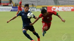 Pemain depan timnas U-19 Indonesia, Riyanto (kanan) berebut bola dengan gelandang timnas U-19 Singapura, Muhd Zulqarnaen bin Suzliman saat berlaga di Stadion GBK Jakarta, (8/12/2014). Indonesia unggul 1-0 atas Singapura. (Liputan6.com/Helmi Fithriansyah)