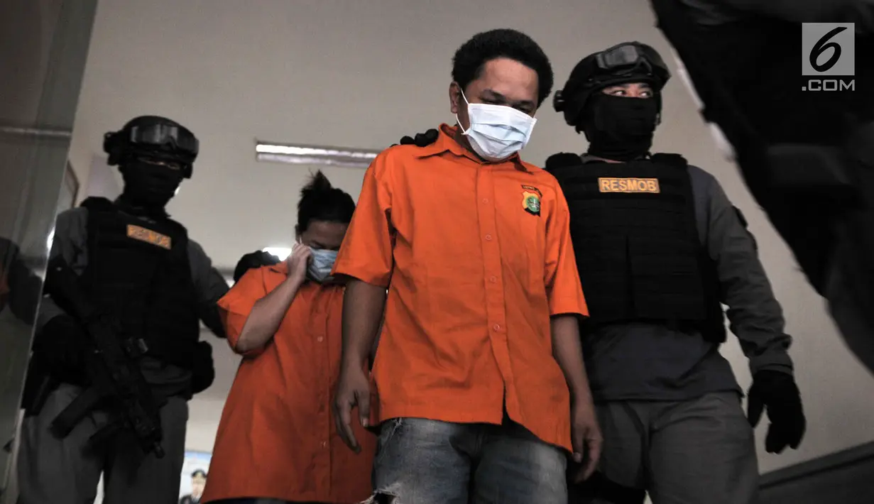 Polisi menggiring dua tersangka kasus prostitusi online di Apartemen Kalibata City, Jakarta, Minggu (6/5). Polisi mengamankan dua tersangka berinisial H alias A (31) dan M alias R (35) selaku muncikari. (Merdeka.com/Iqbal Nugroho)