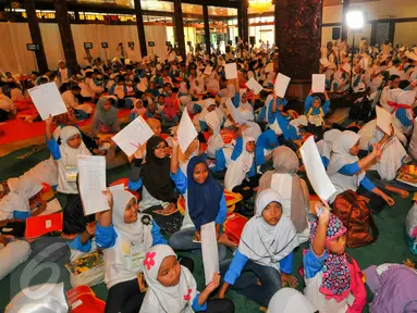 Sebanyak 1.500 anak yatim dan duafa mengikuti kegiatan menulis surat untuk Presiden Jokowi di TMII, Jakarta, Minggu (19/6). Kegiatan tersebut untuk memacu anak berani menuangkan gagasan dan harapannya melalui tulisan tangan. (Liputan6.com/Yoppy Renato)