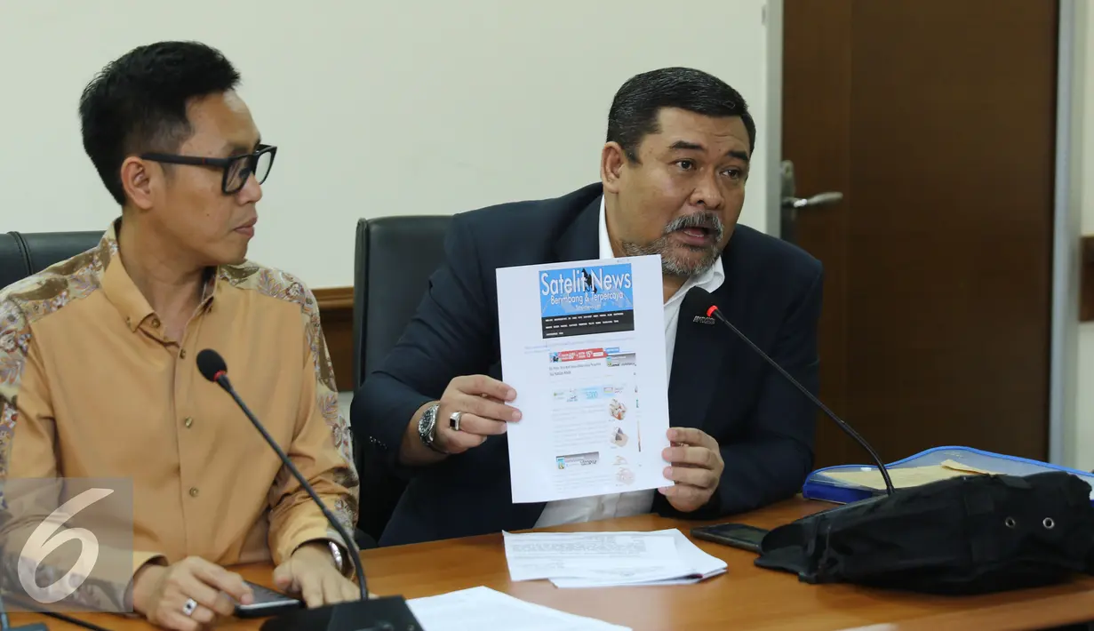 Kuasa hukum Eko Patrio memperlihatkan salah satu media yang memberitakan tidak benar saat memberikan keterangan pers di gedung Dewan Pres, Jakarta, Rabu (21/12). (Liputan6.com/Herman Zakharia)