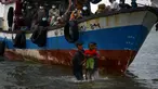 Nelayan Aceh membantu evakuasi seorang anak pengungsi etnis Rohingya menuju pesisir pantai desa Lancok, di Kabupaten Aceh Utara, Kamis (25/6/2020). Hampir 100 orang etnis Rohingya, termasuk 30 orang anak-anak ditemukan terdampar di tengah laut dengan kondisi kapal rusak. (CHAIDEER MAHYUDDIN/AFP)