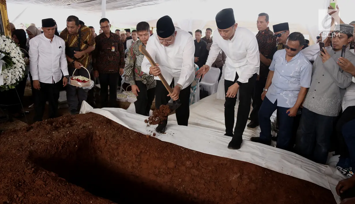 Presiden ke-6 Susilo Bambang Yudhoyono (SBY) disaksikan Agus Harimurti menaburkan tanah yang pertama kali ke makam sang ibu, Siti Habibah, di TPU Tanah Kusir Jakarta, Sabtu (31/8/2019). Ibunda SBY, almarhumah Siti Habibah meninggal pada Jumat (30/8) pukul 19.21 WIB. (merdeka.com/magang/Ahmad Sujana)