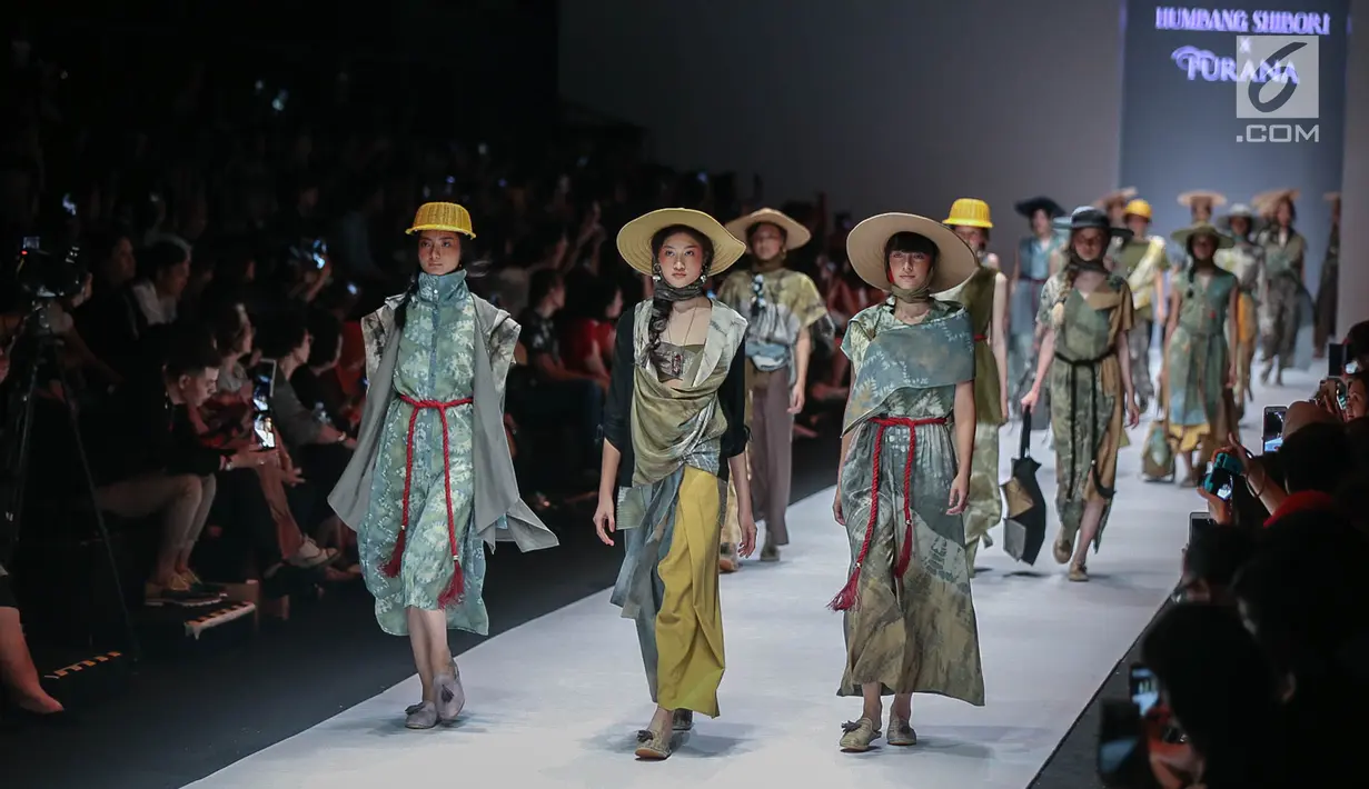 Model memperagakan busana rancangan HUMBANG SHIBORI x PURANA saat Jakarta Fashion Week (JFW) 2019 di Senayan City, Jakarta, Kamis (25/10). HUMBANG SHIBORI x PURANA mengangkat tenun ikat tradisional Humbang Shibori. (Liputan6.com/Faizal Fanani)