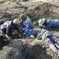 Sekelompok pria mencari di dalam keseluruhan yang mereka gali untuk apa yang mereka yakini sebagai berlian setelah penemuan batu tak dikenal di desa KwaHlathi, luar Ladysmith, Afrika Selatan (15/6/2021). (AFP/Phill Magakoe)