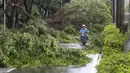 Seorang pengendara motor berada diantara pohon-pohon yang tumbang akibat angin kencang Topan Soudelor di Taipei, Taiwan, (8/8/2015). Empat orang tewas akibat peristiwa angin kencang Topan Soudelor dan hujan deras.  (REUTERS/Pichi Chuang)
