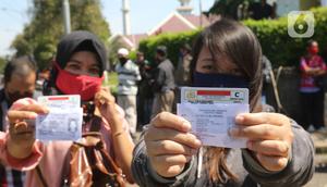 Warga mengurus Surat Izin Mengemudi (SIM) di mobil layanan SIM Keliling Masjid At-Tin, Jakarta Timur, Kamis (4/6/2020). Direktorat Lalu Lintas Polda Metro Jaya mengoperasikan kembali layanan mobil SIM Keliling untuk mengantisipasi antrean pemohon. (Liputan6.com/Herman Zakharia)