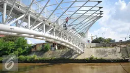 Pembangunan jembatan penyeberangan orang di atas Sungai Ciliwung di kawasan Manggarai segera rampung, Jakarta, Senin (4/4). Rencaanya JPO tersebut siap digunakan pada 6 April mendatang. (Liputan6.com/Yoppy Renato)