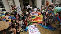 Aksi protes sejumlah wanita dengan mengadakan pesta pantai di luar kedutaan Prancis di London, Inggris, Kamis (25/8). Mereka memprotes larangan burkini (pakaian renang muslimah) yang diberlakukan di beberapa kota pesisir di Prancis. (REUTERS/Neil Hall)