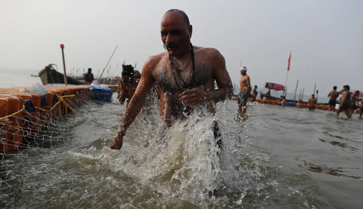 Seorang umat Hindu mandi ritual selama festival Makar Sankranti yang jatuh selama pekan raya tadisional tahunan festival Magh Mela, salah satu ziarah paling suci ajaran Hindu, di Prayagraj, India (14/1/2022). (AP Photo/Rajesh Kumar Singh)