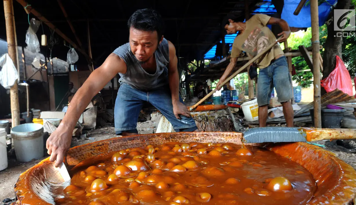 Pekerja membuat dodol Betawi di kawasan Studio Alam TVRI, Cilodong, Depok (31/5). Jelang Lebaran, dalam sehari tempat pembuatan ini dapat menghasilkan 400 kilogram dodol. (Merdeka.com/Arie Basuki)