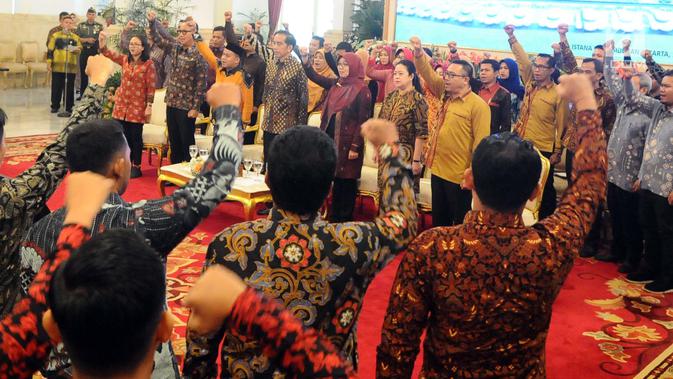 Presiden Joko Widodo (Jokowi) bernyanyi bersama pendamping Program Keluarga Harapan (PKH) dalam Jambore Sumber Daya PKH Tahun 2018 di Istana Negara, Jakarta, Kamis (13/12). Jambore diikuti 598 peserta dari seluruh Indonesia. (Liputan6.com/Angga Yuniar)