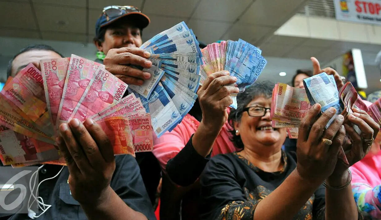 Masyarakat menunjukan mata uang rupiah lama yang akan ditukarkan dengan pecahan mata uang yang baru di Blok M, Jakarta, Senin (19/12). (Liputan6.com/Angga Yuniar)