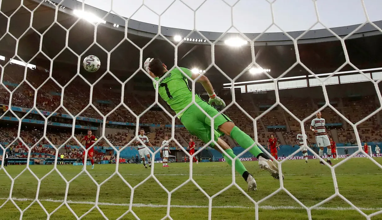 Kiper Portugal Rui Patricio gagal menyelamatkan tembakan pemain Belgia Thorgan Hazard pada pertandingan Euro 2020 di Stadion La Cartuja, Seville, Spanyol, 27 Juni 2021. Thorgan Hazard melesakkan tendangan dari luar kotak penalti dan melengkung sebelum sampai ke gawang. (AP Photo/Thanassis Stavrakis)