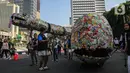 Aktivis lingkungan dari komunitas Aksi Muda Jaga Iklim berpawai dengan membawa replika ikan paus dan ular raksasa yang terbuat dari sampah plastik di kawasan Bundaran Hotel Indonesia, Jakarta, Minggu (27/10/2024). (Liputan6.com/Angga Yuniar)