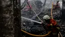 Petugas pemadam kebakaran melakukan pendinginan usai kebakaran yang melanda gudang kosmetik di Jalan Bandengan 1 No 56, RT 04/12, Kelurahan Pekojan, Kecamatan Tambora, Jakarta Barat, Senin (4/12). (Liputan6.com/Faizal Fanani)