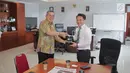 Sekretaris SCM Gilang Iskandar memberikan plakat kepada Biro Komunikasi dan layanan Informasi Kementerian Keuangan Nufransa Wira Sakti usai beraudensi di Gedung Djuanda 1, Jakarta, Selasa (1/10/2019). Pertemuan tersebut membahas kerja sama di bidang sektor media. (Liputan6.com/Faizal Fanani)