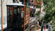 Seorang pejalan kaki melintas di sebelah kereta api Angels Flight di pusat kota Los Angeles, AS (28/8). Kereta api Angels Flight memilik rel sepanjang 91 meter dan dijuluki rel paling pendek di dunia. (AP Photo / Richard Vogel)