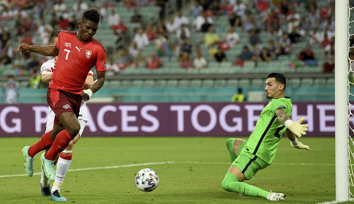 Giliran Swiss yang membalas ancaman para pemain Turki. Striker Breel Embolo melepaskan tendangan di mulut gawang Turki yang masih bisa dihalau kiper Ugurcan Cakir. (Foto: AP/Pool/Ozan Kose)