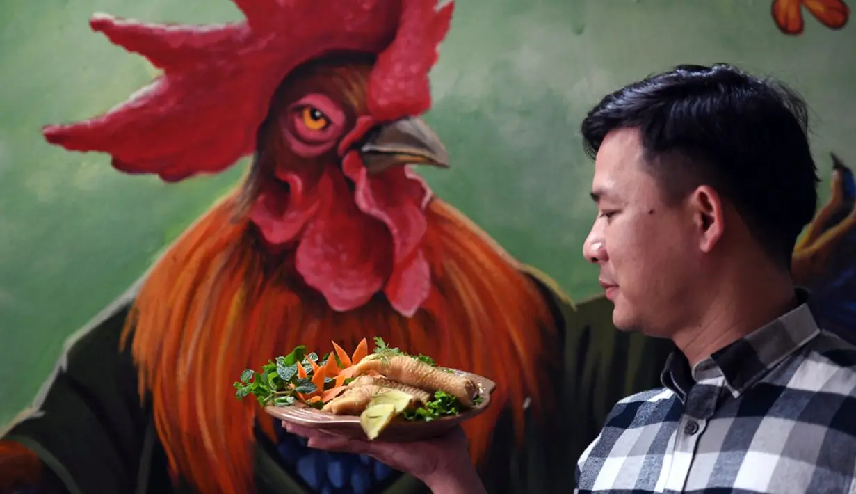 Seorang koki membawa hidangan kaki ayam Dong Tao yang telah disiapkan di sebuah restoran di Hanoi, Vietnam, 15 Januari 2023. Karena menjadi salah satu spesies ayam langka, sepasang ayam Dong Tau bisa dibanderol mencapai 2.500 dolar atau setara dengan lebih dari Rp 300 juta. (Nhac NGUYEN/AFP)
