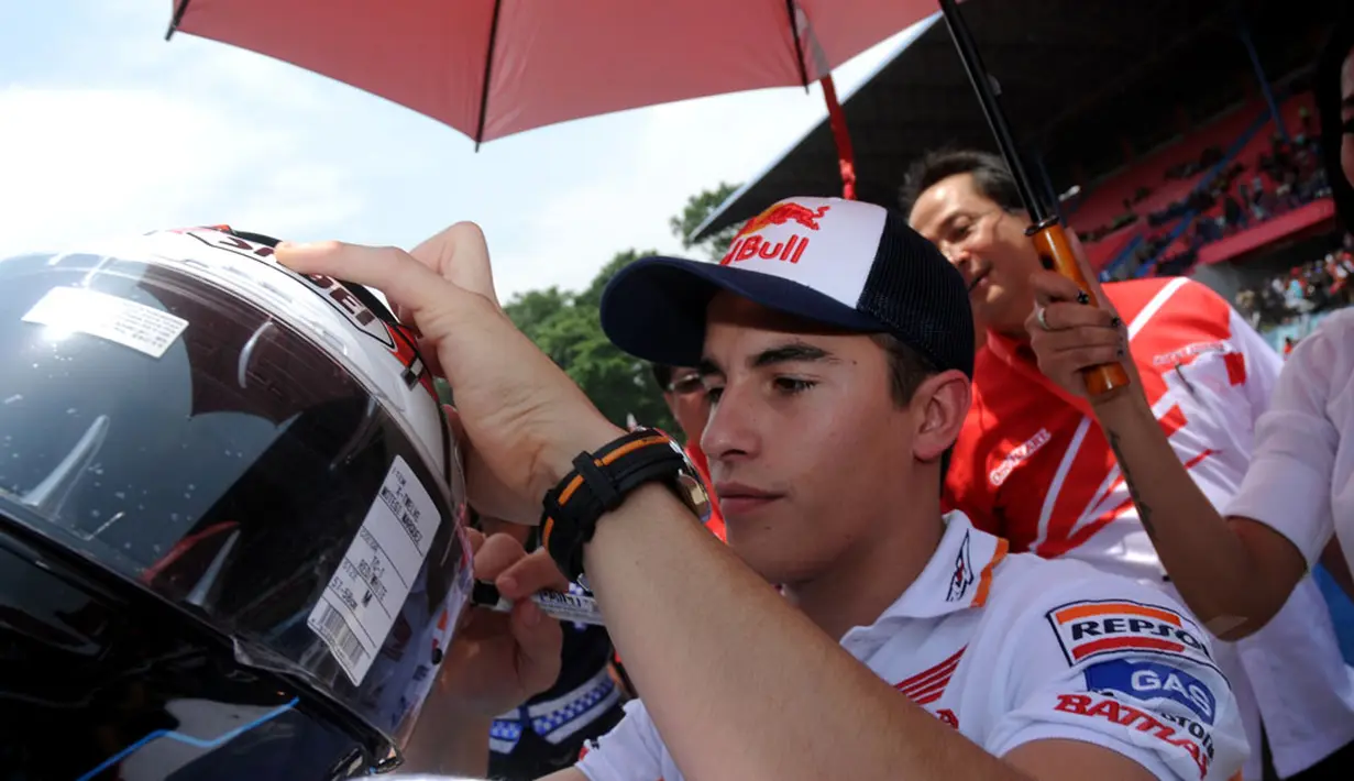 Juara Dunia MotoGP 2013 dan 2014, Marc Marquez menandatangi helm salah satu penggemarnya disela-sela acara Meet & Greet di Sirkuit Sentul, Bogor, (21/10/2014). (Liputan6.com/Helmi Fithriansyah)