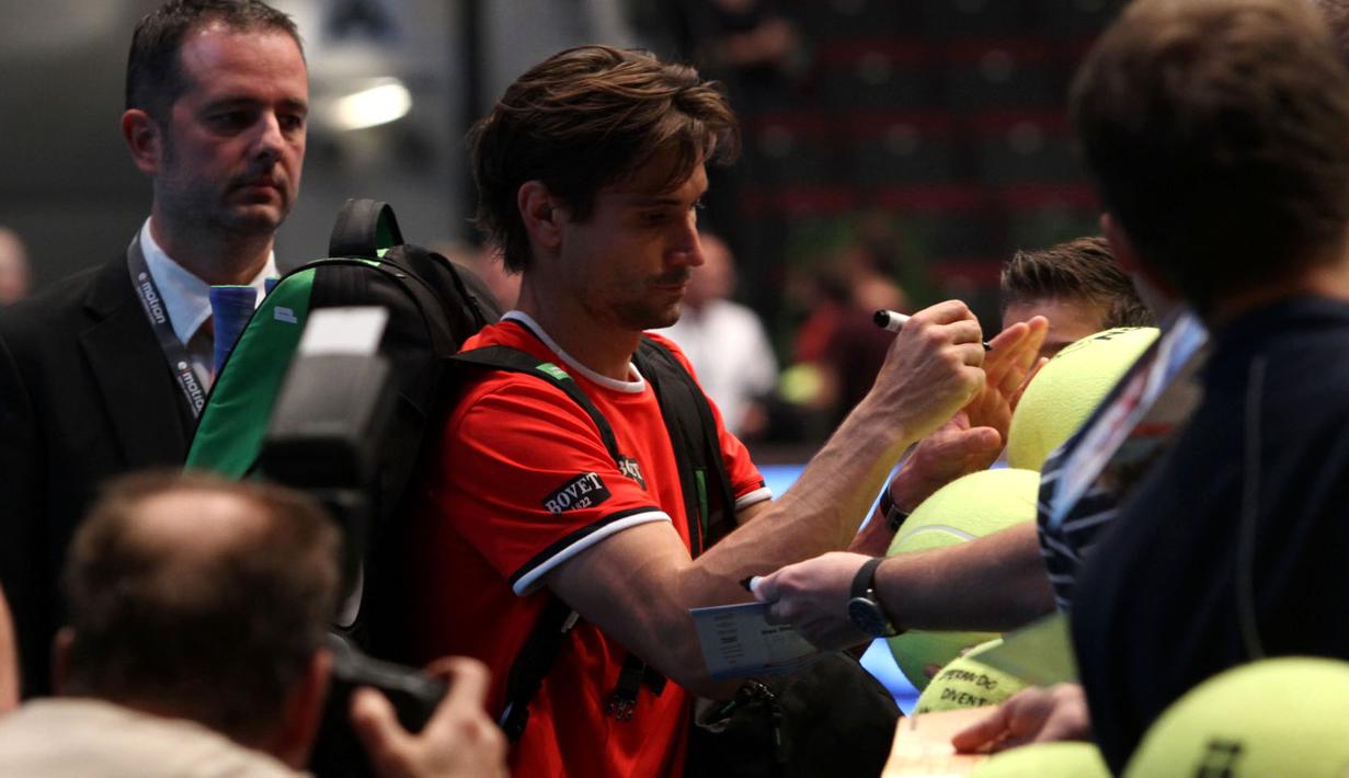 David Ferrer melayani permintaan tanda tangan dari puluhan fans yang antre di pintu masuk arena pertandingan di Stadthalle Arena, Minggu, (25/10/2015) malam WIB. (Bola.com/Reza Khomaini)