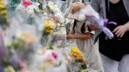 Seorang gadis manaruh bunga untuk untuk korban Penikaman Massal yang terjadi di Kawasaki, Jepang (29/5/2019). PM Jepang, Shinzo Abe, menyatakan kemarahan atas penikaman massal di Kawasaki yang juga melukai belasan siswa Sekolah Dasar (SD) ini. (Reuters/Issei Kato)