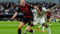 Penyerang Man City, Erling Haaland saat dibayangi bek Real Madrid, Antonio Rudiger pada leg pertama semifinal Liga Champions 2022/2023, Rabu (10/5/2023) dini hari WIB. (AP Photo/Jose Breton)