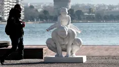 Seorang pria berjalan di samping patung karya seniman China Xu Hongfei di Thessaloniki, Yunani, Rabu (19/12). Sebanyak 15 patung karya Xu Hongfei menghiasi tepi pantai Thessaloniki. (Sakis Mitrolidis/AFP)