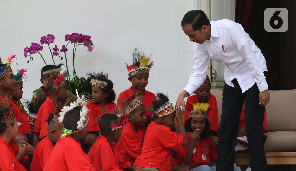 Presiden Joko Widodo atau Jokowi menyalami perwakilan anak-anak sekolah dasar dari Papua di Istana Merdeka, Jakarta, Jumat (11/10/2019). Jokowi mengaku sudah berjanji untuk mengundang mereka ke istana saat mengunjungi Jayapura dan Asmat. (Liputan6.com/Angga Yuniar)