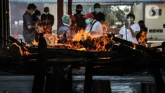 Petugas mengenakan APD saat proses kremasi jenazah pasien Covid-19 di Krematorium Cilincing, Jakarta Utara, Minggu (25/7/2021). Layanan kremasi jenazah pasien Covid-19 di Krematorium Cilincing terus bergeliat sejak dibuka pada 19 Juli 2021. (merdeka.com/Iqbal S Nugroho)