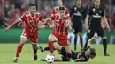 Pemain Real Madrid, Luka Modric jatuh saat berebut bola dengan pemain Bayern, Thiago dan James Rodriguez pada leg pertama semfinal Liga Champions di Allianz Arena, Munich, (25/4/2018). Real Madrid menang 2-1. (AP/Matthias Schrader)