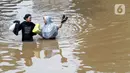 Warga berjalan menyusuri banjir yang menggenangi sebagian ruas Jalan Warung Buncit Raya, Jakarta, Sabtu (20/2/2021). Hujan yang mengguyur Jakarta sejak Jumat (19/2) membuat arus lalu lintas sejumlah jalan di Jakarta lumpuh akibat terendam banjir. (Liputan6.com/Helmi Fithriansyah)