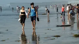 Orang-orang mengunjungi pantai di Playas de Tijuana dekat perbatasan AS-Meksiko di Tijuana Meksiko, Sabtu (3/10/2020). Akhir pekan ini pantai di Playas de Tijuana dibuka kembali dengan pembatasan pengunjung, setelah ditutup sejak Maret lalu guna mencegah penyebaran Covid-19. (Guillermo Arias/AFP)