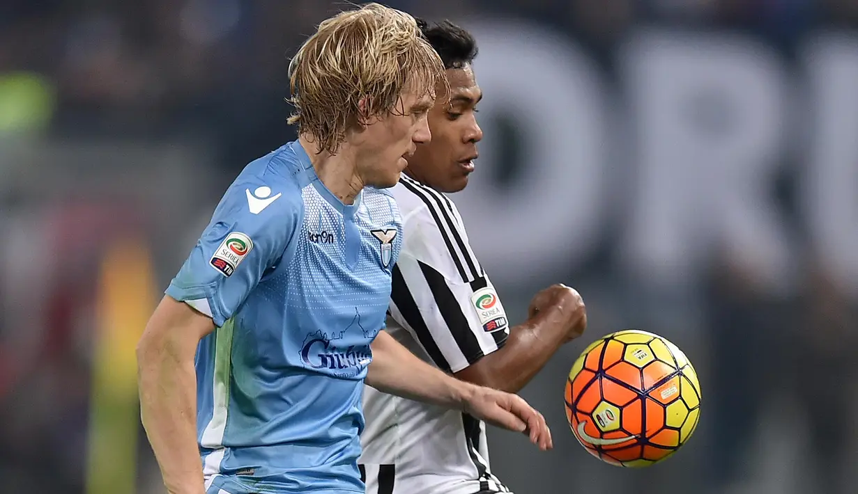 Pemain Juventus,  Alex Sandro (kanan) berebut bola dengan pemain Lazio, Dusan Basta pada lanjutan Liga Italia Serie A di Stadion Olimpico, Sabtu (5/12/2015) dini hari WIB. (AFP Photo/Alberto Pizzoli)