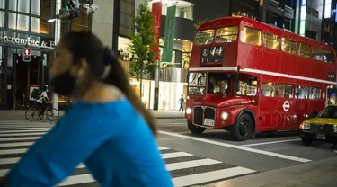 Sebuah bus bertingkat yang digunakan untuk iklan melintasi kota menunggu di lampu lalu lintas di distrik perbelanjaan Ginza Tokyo, Kamis (23/9/2021). Kawasan ini dikenal sebagai kawasan mewah di Tokyo. (AP Photo/Hiro Komae)