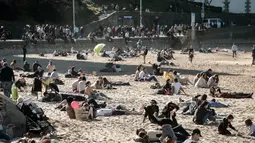 Penduduk dan turis duduk di pantai berpasir selama cuaca musim dingin yang hangat di Biarritz di Perancis barat (17/2). Kawasan pantai Biarritz yang berbatasan dengan Spanyol ini termasuk salah satu wilayah termahal di Prancis. (AFP Photo/Iroz Gaizka)