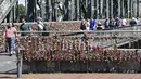 Warga melewati gembok cinta di sebuah jembatan di Cologne, Jerman, Rabu, (5/8/2020). Sebagai bukti cinta mereka, puluhan ribu pasangan telah memasang gembok selama bertahun-tahun ke pagar di Jembatan Hohenzollern sebelum melemparkan kunci ke dalam Sungai Rhein di bawah. (AP Photo/ Martin Meissner)