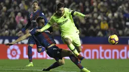 Bek Levante, Sergio Postigo, berebut bola dengan gelandang Barcelona, Lionel Messi, pada laga La Liga di Stadion Ciutat de Valencia, Valencia, Minggu (16/12). Levante kalah 0-5 dari Barcelona. (AFP/Jose Jordan)