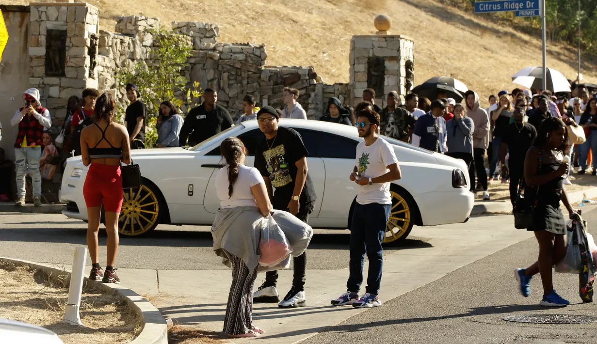 Penggemar membawa barang-barang yang dijual penyanyi AS, Chris Brown di lingkungan Tarzana, Los Angeles, 6 November 2019. Ratusan orang berkumpul setelah Chris Brown mengumumkan penjualan barang-barang di sekitaran halamannya melalui akun Instagram dan Twitter-nya. (AP/Damian Dovarganes)