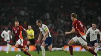 Penyerang Inggris Harry Kane berlari melewati pertahanan Latvia selama pertandingan sepak bola kualifikasi Piala Dunia 2026 Grup K antara Inggris dan Latvia, di stadion Wembley, London, pada 24 Maret 2025.Glyn KIRK / AFP
