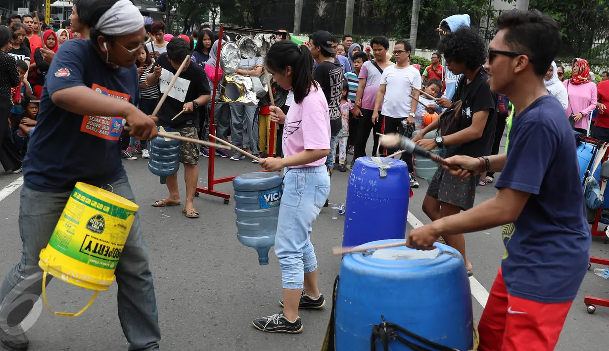 Penampilan dari Kreasi Musik Mahasiswa IISIP yang memainkan alat musik dari barang bekas di kawasan Bundaran HI, Jakarta, Minggu (14/5). Pertunjukkan musik tersebut bertujuan untuk mengalang dana. (Liputan6.com/Immanuel Antonius)