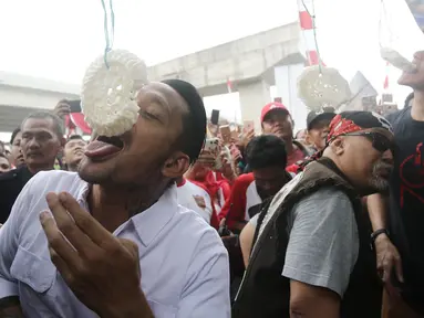 Aktor Tora Sudiro, Vino G Bastian dan Indro Warkop mengikuti lomba makan kerupuk pada Festival Kalimalang di Jakarta, Kamis (17/8). Mereka menghadiri festival Kalimalang dalam rangka promo film Warkop DKI: Reborn Part 2. (Liputan6.com/Herman Zakharia)