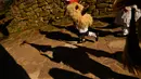 Seorang anak mengenakan kostum dengan latar belakang bayangan peserta karnaval di antara desa Pyrenees Ituren dan Zubieta, Spanyol (29/1). Acara ini merupakan salah satu karnaval paling kuno di Eropa. (AP Photo / Alvaro Barrientos)